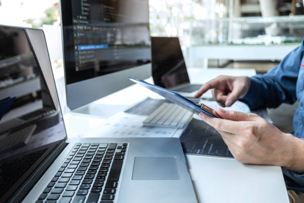 Developer programmer working on project in software development computer in IT company office, Writing codes and data code website and coding database technologies to find solution to problem.